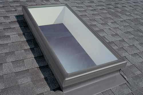 Skylight window on a shingle roof.